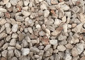 Crushed limestone aggregate with warm caliche staining, stocked at the Triple C Concrete yard.